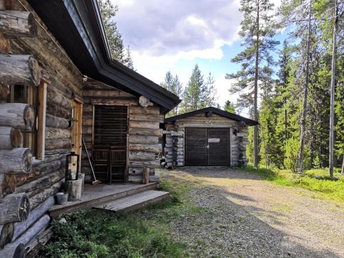 a log cabin with a garage in the woods at Kelokallas 2 Ruka in Ruka