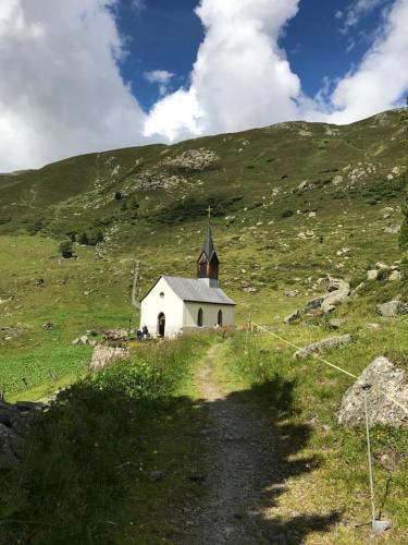 a small white church on a grassy hill at Ferienapartment Davos in Davos