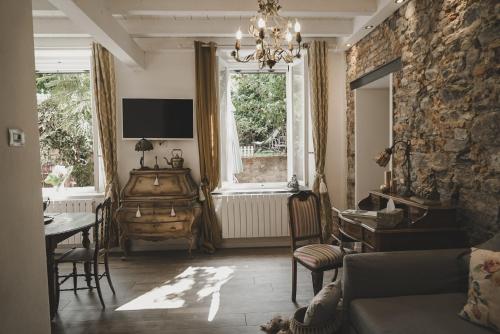 un soggiorno con divano, tavolo e finestre di Il Giardino Segreto Arona ad Arona