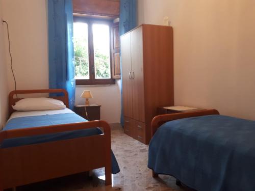 1 dormitorio con 2 camas, armario y ventana en Acquamarine, en Marina di Fuscaldo