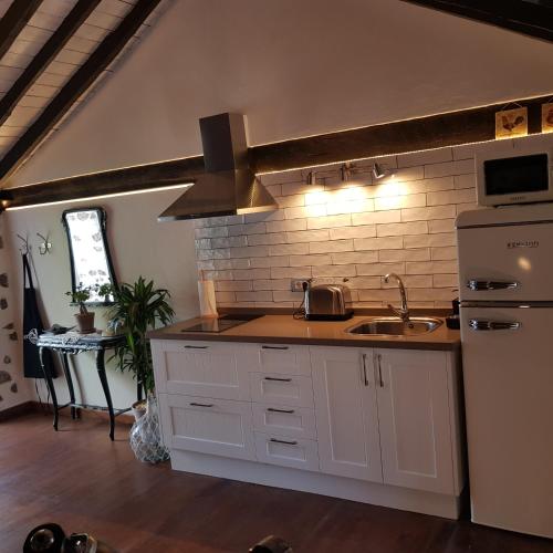a kitchen with a sink and a stove top oven at Elescondite in Sauzal