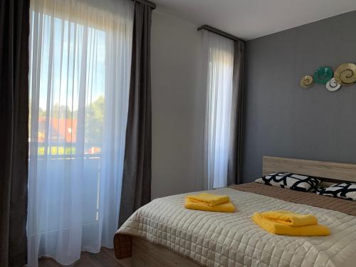 een slaapkamer met een bed met gele handdoeken erop bij Naplemente Apartman in Balatonfüred