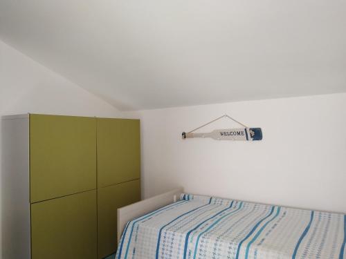 ジョイオーザ・マレーアにあるLe Terrazze di Calava'のベッドルーム1室(ベッド1台付)、緑のキャビネットが備わります。