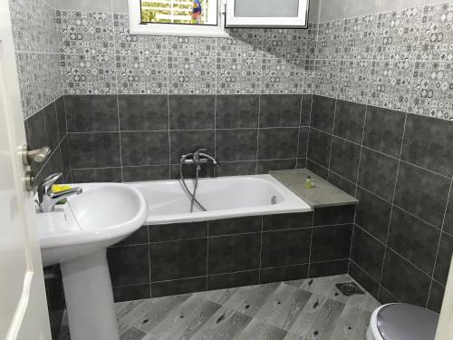 a bathroom with a bath tub and a sink at Maison de Vacances Tazarka in Tazarka