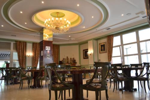 een eetkamer met een kroonluchter en tafels en stoelen bij Hotel Camino de Santiago in Castrillo del Val