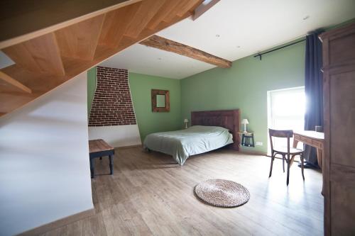 een slaapkamer met een bed en een bureau in een kamer bij Les Chambres d'hotes de Sophie in Piennes