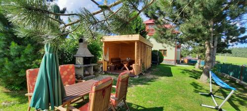 a backyard with a wooden bench and a fireplace at Privát Tatry Štrba in Štrba