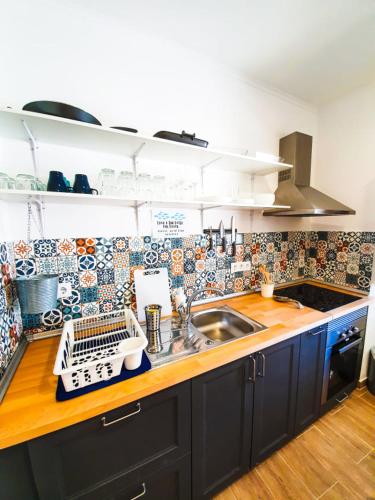 a kitchen with a sink and a counter top at PÊPA Guesthouse in Setúbal