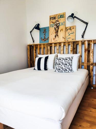 a bedroom with a white bed with two lamps at PÊPA Guesthouse in Setúbal