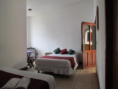 Habitación de hotel con 2 camas y espejo en Casa Natura en San Cristóbal de Las Casas