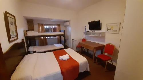 a hotel room with a bed and a desk and a television at Hotel Gaviota in Montevideo