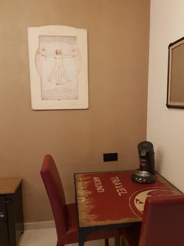 una mesa y sillas con un dibujo en la pared en Da Vinci Room VILLA BLANCA Cambrils, en Cambrils