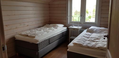 zwei Einzelbetten in einem Zimmer mit Fenster in der Unterkunft The Blue House - Luxurious Waterfront Villa Zeewolde in Zeewolde