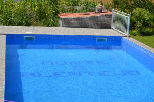 une grande piscine bleue avec un panneau. dans l'établissement Monte O Alentejo, à Ourique