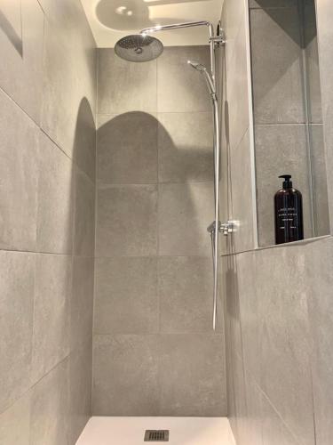 a bathroom with a shower with a bottle on the wall at Appartement Giulia in Knokke-Heist