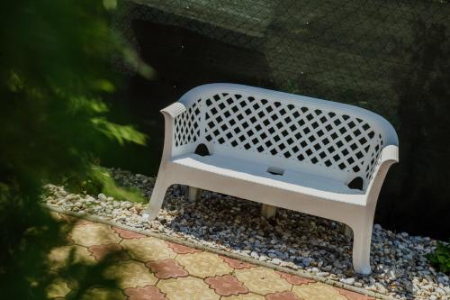 a white bench sitting on a pebbleysenalsenalsenalsenalsenalsenalsenal at Vila Adria in Hrabušice