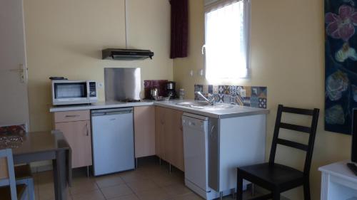 a small kitchen with a sink and a microwave at Apartment Le Jardinet in Talence