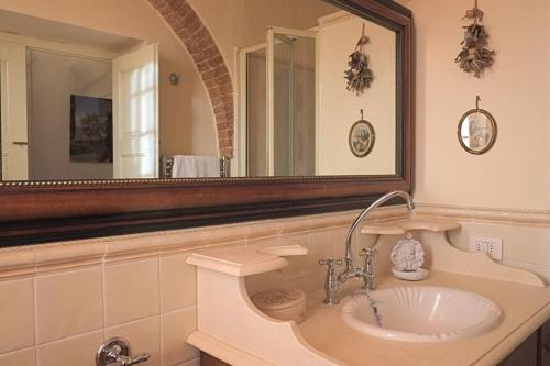 ein Badezimmer mit einem Waschbecken und einem großen Spiegel in der Unterkunft Nido verde in Montefollonico