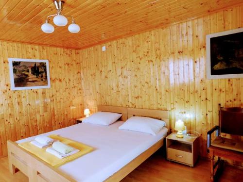 une chambre avec un lit dans un mur en bois dans l'établissement Apartments Neno, à Korčula