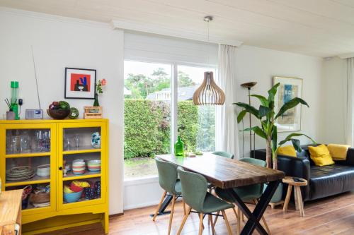 a living room with a table and a yellow cabinet at Vakantiehuisje Specht in Otterlo