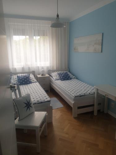 グディニャにあるRosA III -3 pokoje- Gdyniaのベッド2台と椅子が備わる客室です。