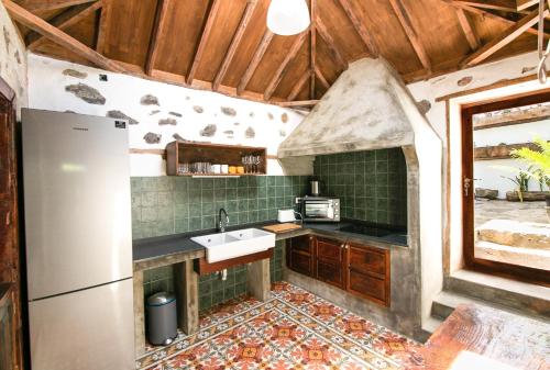 a kitchen with a sink and a refrigerator at Casa 1820 by Rural La Palma in Santa Cruz de la Palma