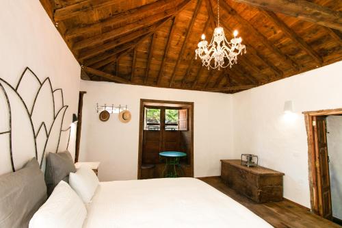 a bedroom with a white bed and a chandelier at Casa 1820 by Rural La Palma in Santa Cruz de la Palma