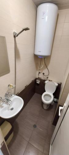 La petite salle de bains est pourvue de toilettes et d'un lavabo. dans l'établissement Къща за гости ЕЛИ, à Primorsko