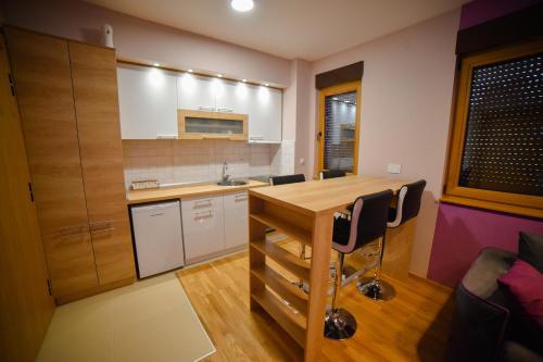 a kitchen with a wooden table and black chairs at AMETIST10 in Zlatibor