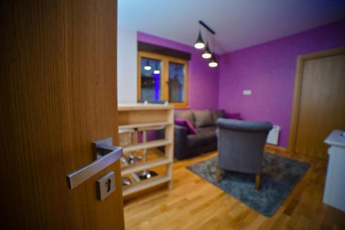 a living room with purple walls and a chair at AMETIST10 in Zlatibor