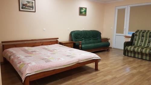 a bedroom with a bed and two green chairs at Jurmala Diamond in Jūrmala
