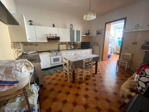 a kitchen with a table and a kitchen with white cabinets at nena in Diso