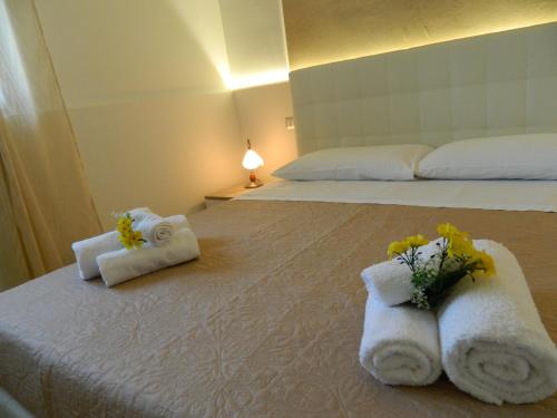 a hotel room with towels and flowers on a bed at A Casa di Anna - Locazione Turistica - in Matera