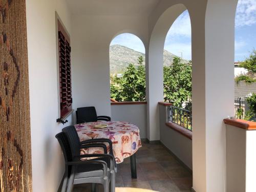 een eetkamer met een tafel en twee ramen bij Appartamento in Villa Andreina in Orosei