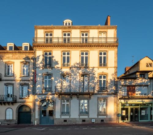 a building with a balcony on the side of it at Hôtel de Paris in Limoges