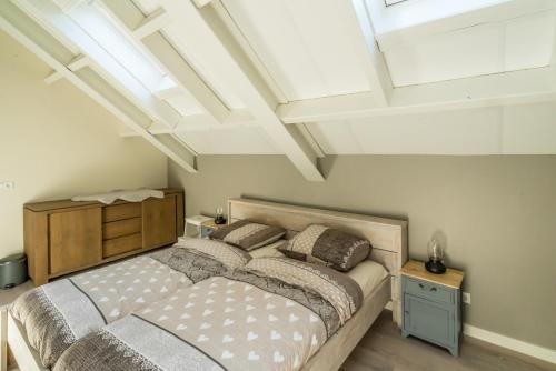 um quarto com uma cama grande e algumas clarabóias em Job Baster Huisje em Zierikzee