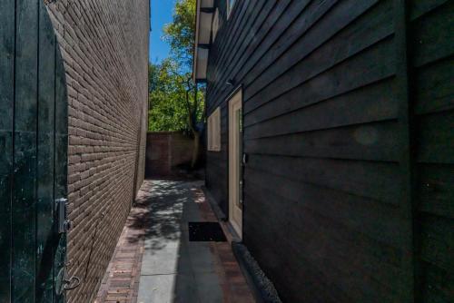 an alley between two buildings with a door on the side at Job Baster Huisje in Zierikzee