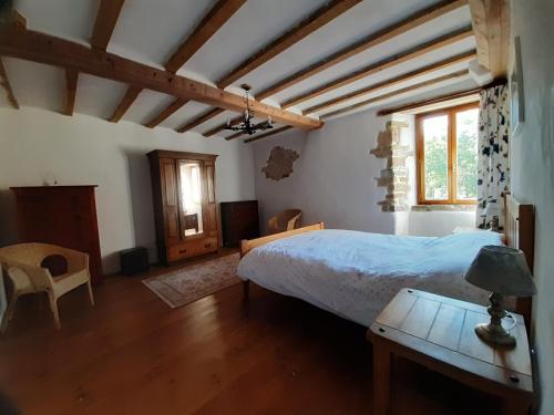 une chambre avec un lit et une table avec une lampe dans l'établissement Les Rivieres, à Saint-Germain-sur-Sèves