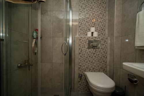 a bathroom with a shower with a toilet and a sink at ESQUIRE HOTELS and LOUNGES in Kemer