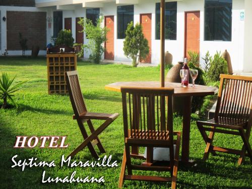 a table with two chairs and a table with a bottle of wine at Hotel Septima Maravilla Lunahuana in Lunahuaná