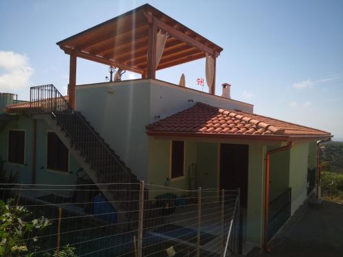 a small house with a wooden roof and a staircase at Appartamento Belvedere Sassos P 3267 in Tresnuraghes