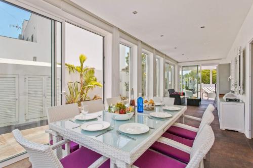 a dining room with a table and some chairs at Villa Maresia Dourada in Guia