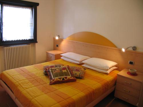 a bedroom with a yellow bed with two pillows on it at Art Apartments Casa Napell in Livigno