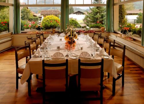 a long dining table in a room with windows at Hotel Beausite in Interlaken