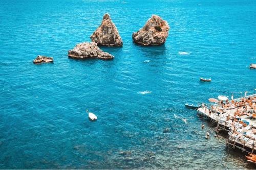 a group of people on a beach with rocks in the water at Casa vacanze Amalfitan Coast in Vietri sul Mare