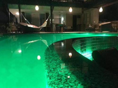 a swimming pool with green lights in a house at Pousada Maracabana Spa in Porto De Galinhas