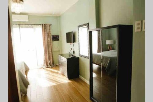 a room with a bedroom with a bed and a mirror at Franzon Apartment in Mactan