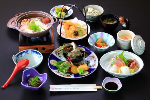 Tsushima Grand Hotel في تسوشيما: طاولة مع أطباق من الطعام وأوعية من الطعام