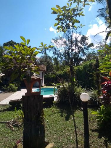 a resort with a swimming pool and trees at Armazém do Porto Chalé Jasmim in Morretes
