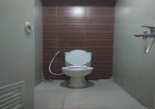 a bathroom with a white toilet in a stall at The Edge By Orin in Cimindi-hilir